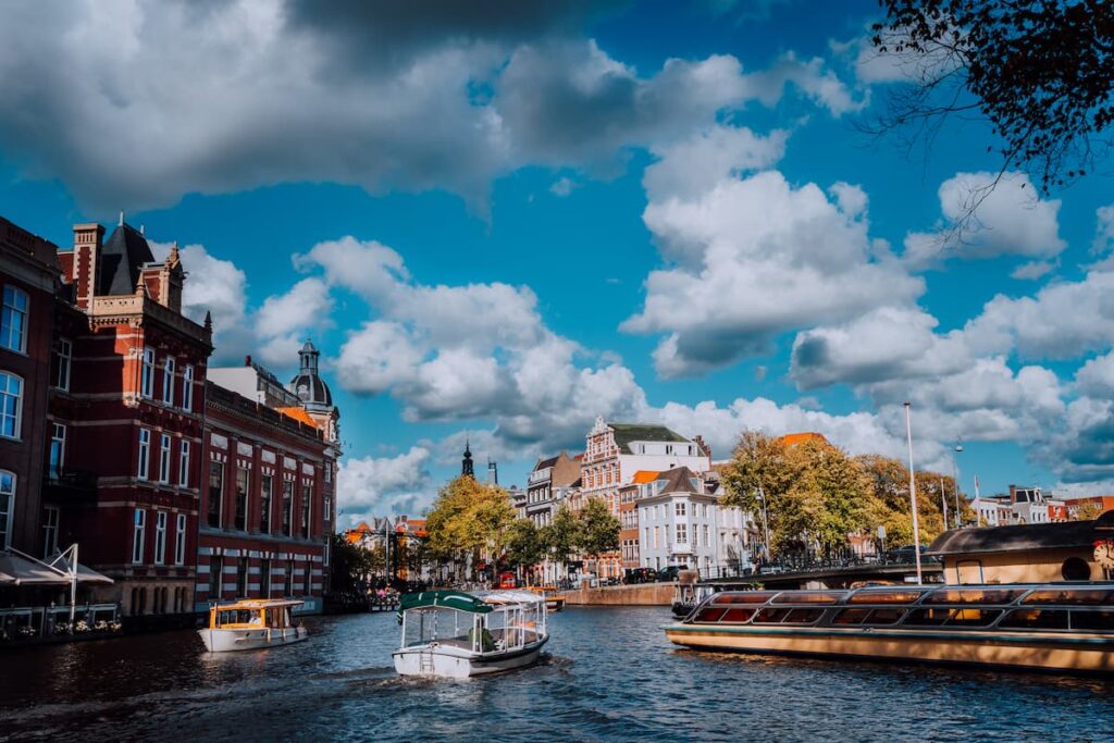 Imagem mostra barcos flutuantes pelos canais de Amsterdã.
