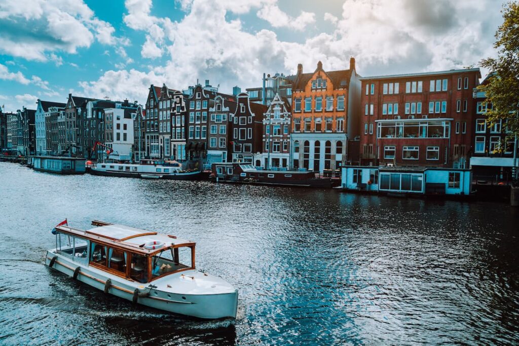 Imagem mostra barco semiaberto, usado para fazer os passeios de barco em Amsterdã.