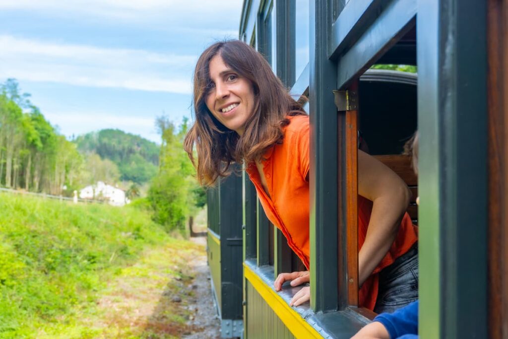 Imagem mostra jovem feliz fazendo o passeio de trem em Apiúna.