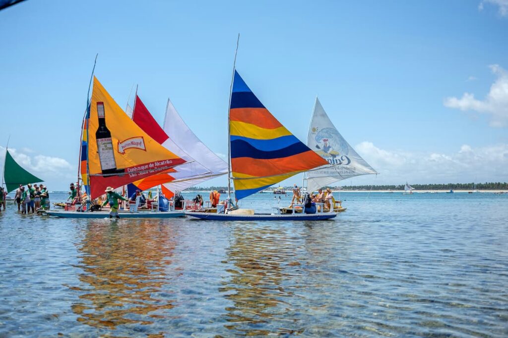 Imagem mostra grupo de turistas em praia de Porto de Galinhas.