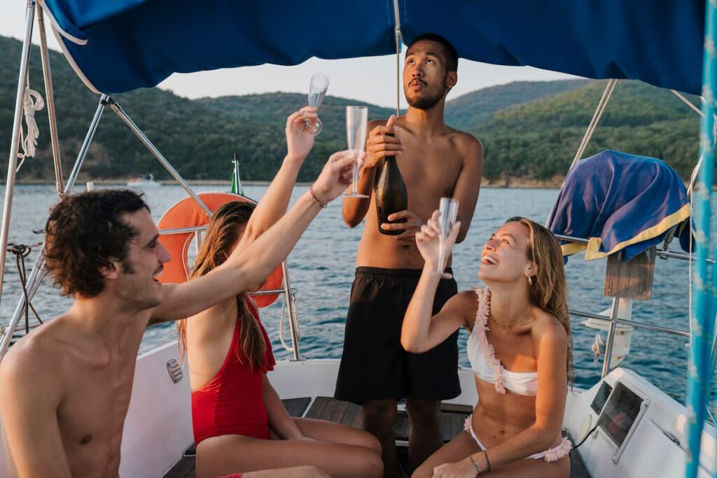 Imagem mostra grupo de amigos brindando em passeio de escuna.