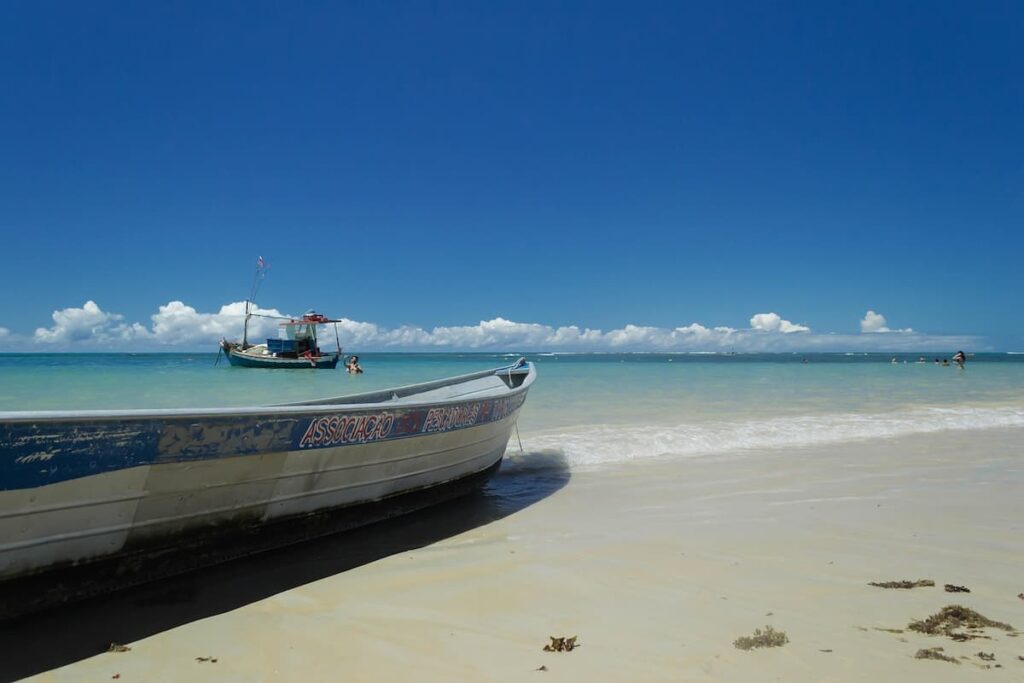 Imagem mostra passeio de barco em Trancoso, BA.