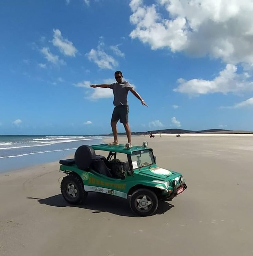 Imagem mostra turista em passeio de buggy em Jericoacoara, Ceará.