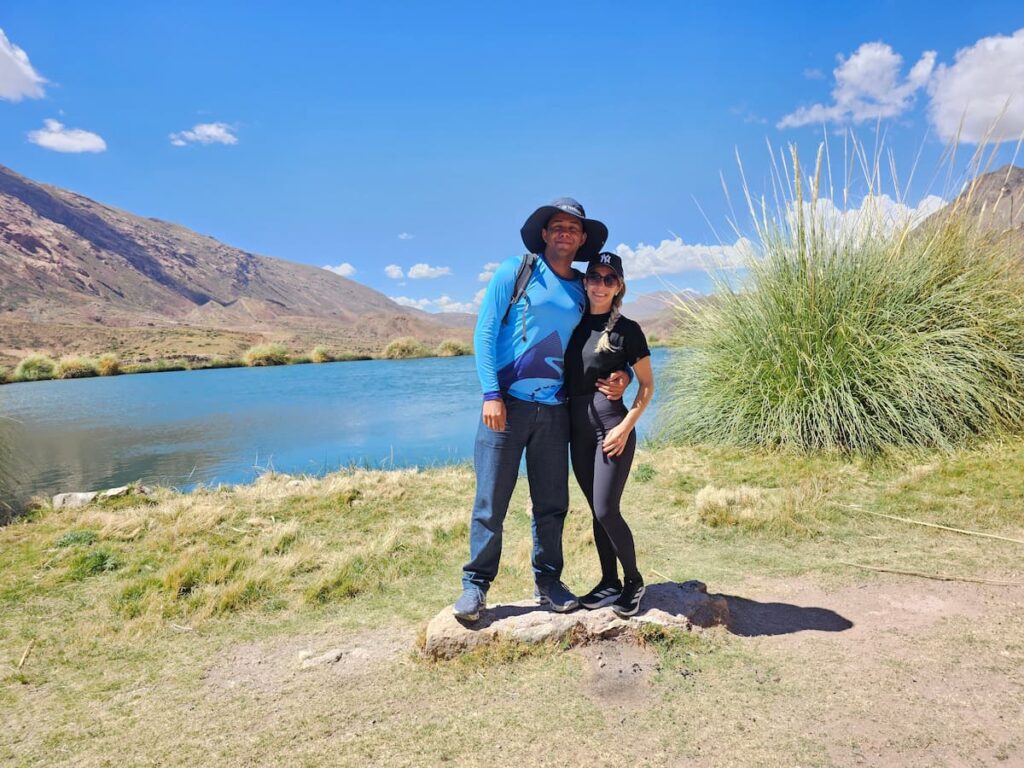 Imagem mostra turistas visitando o Ojo del Inca em Potosí, um dos melhores passeios na Bolívia.