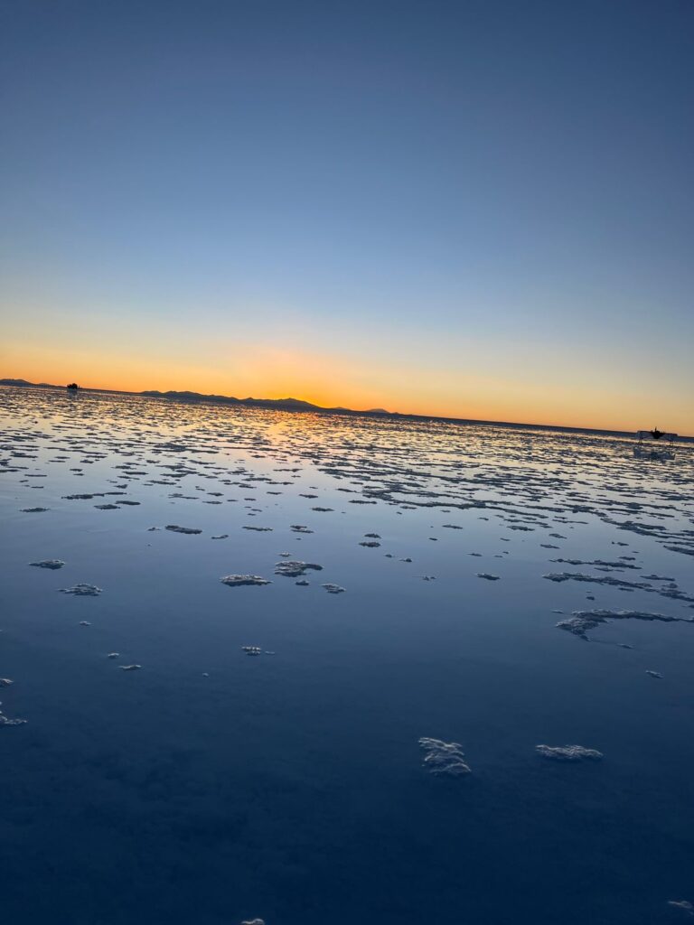 Imagem mostra o Salar de Uyuni ao pôr do Sol.