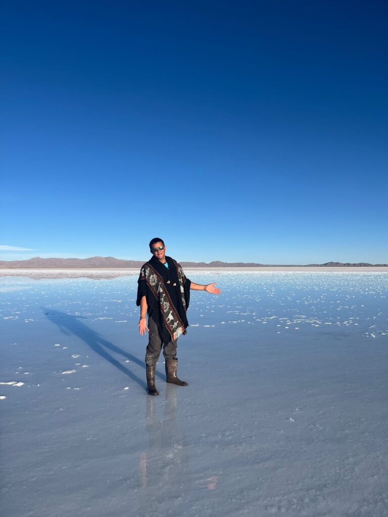 Imagem mostra turista tirando foto nofim de tarde no maior deserto de sal do mundo.