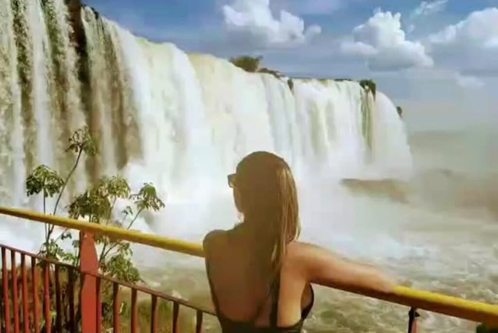 Imagem mostra turista observando a enorme queda d'água nas cataratas do Iguaçu lado brasileiro.